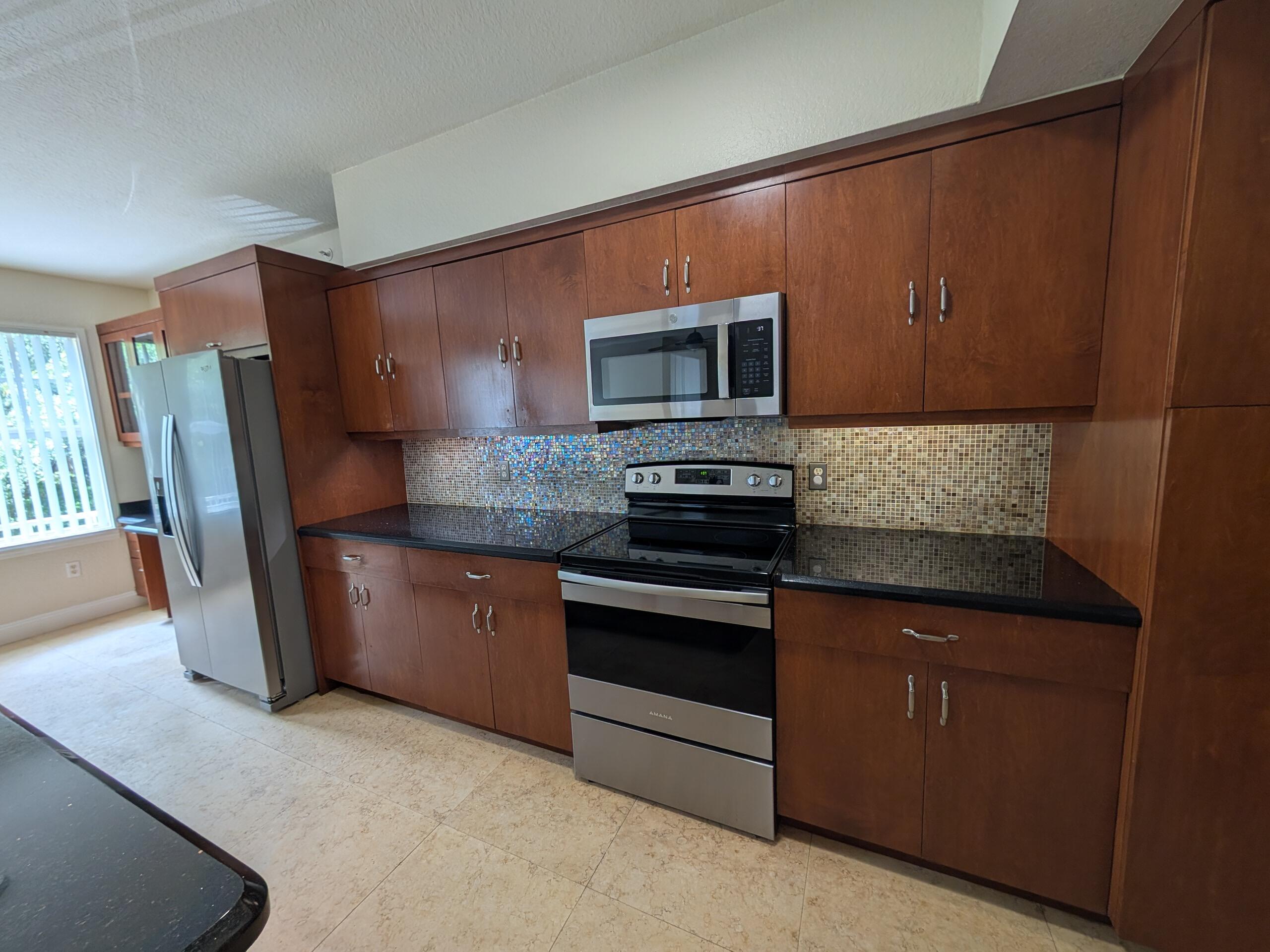 a kitchen with stainless steel appliances granite countertop wooden cabinets a stove top oven a sink and dishwasher