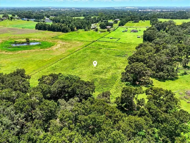 an aerial view of a houses with a lush green hillside and houses