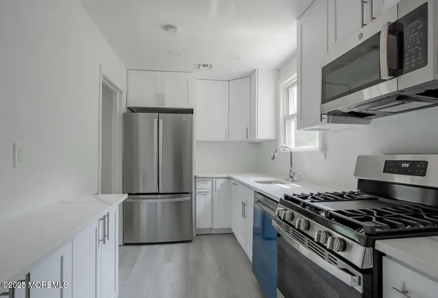 a kitchen with stainless steel appliances granite countertop a stove a refrigerator and a microwave