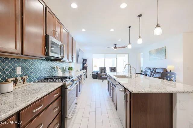 a kitchen with lots of counter space a sink appliances and cabinets