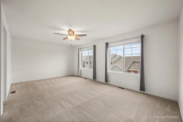 an empty room with fan and windows