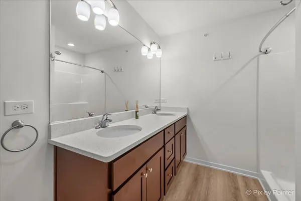 a bathroom with a sink a toilet a mirror and shower
