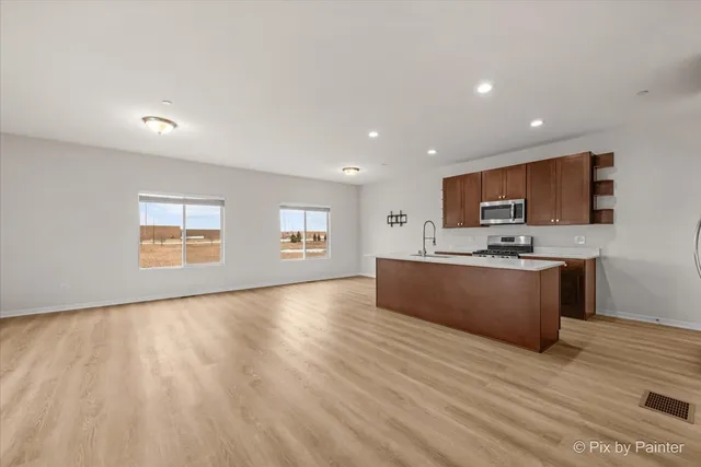 a large kitchen with kitchen island granite countertop a sink window and stainless steel appliances