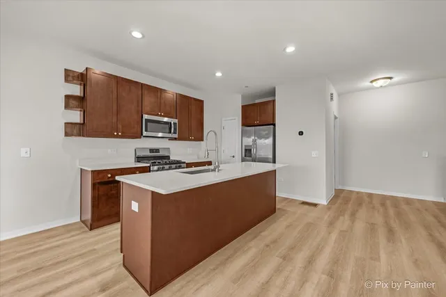 a kitchen with stainless steel appliances granite countertop a stove a sink and a refrigerator