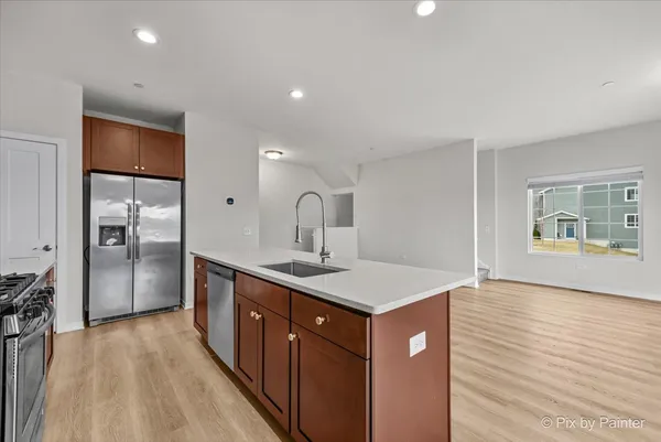 a kitchen with a sink a refrigerator and wooden floor