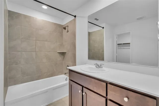 a bathroom with a bathtub shower sink and vanity