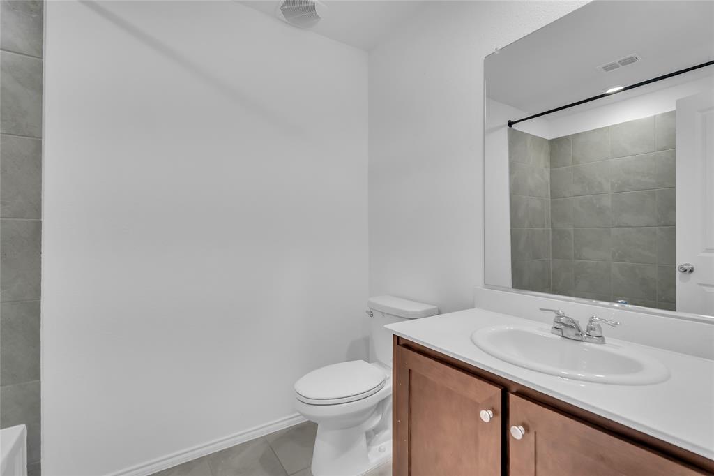 14069 Drover Street Pilot Point, TX 76258 - Photo 20 of 27 a bathroom with a granite countertop sink toilet and a mirror