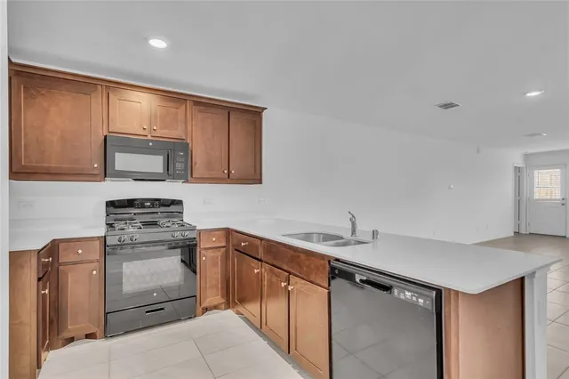a kitchen with stainless steel appliances granite countertop a sink stove and microwave