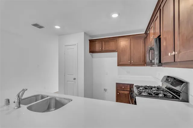 a kitchen with sink refrigerator and stove