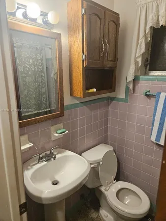 a bathroom with a toilet a sink and mirror