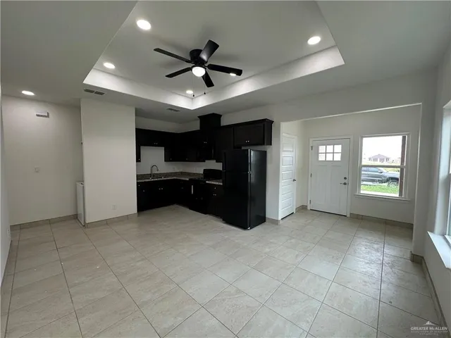 a view of an empty room with window and cabinet