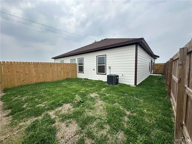 a view of a backyard with wooden fence