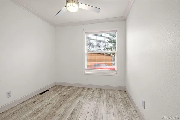 an empty room with a hardwood and a window