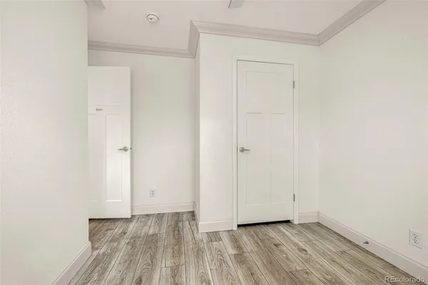 a view of an empty room with wooden floor