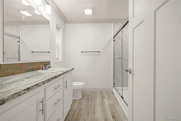 a bathroom with a granite countertop sink toilet and shower