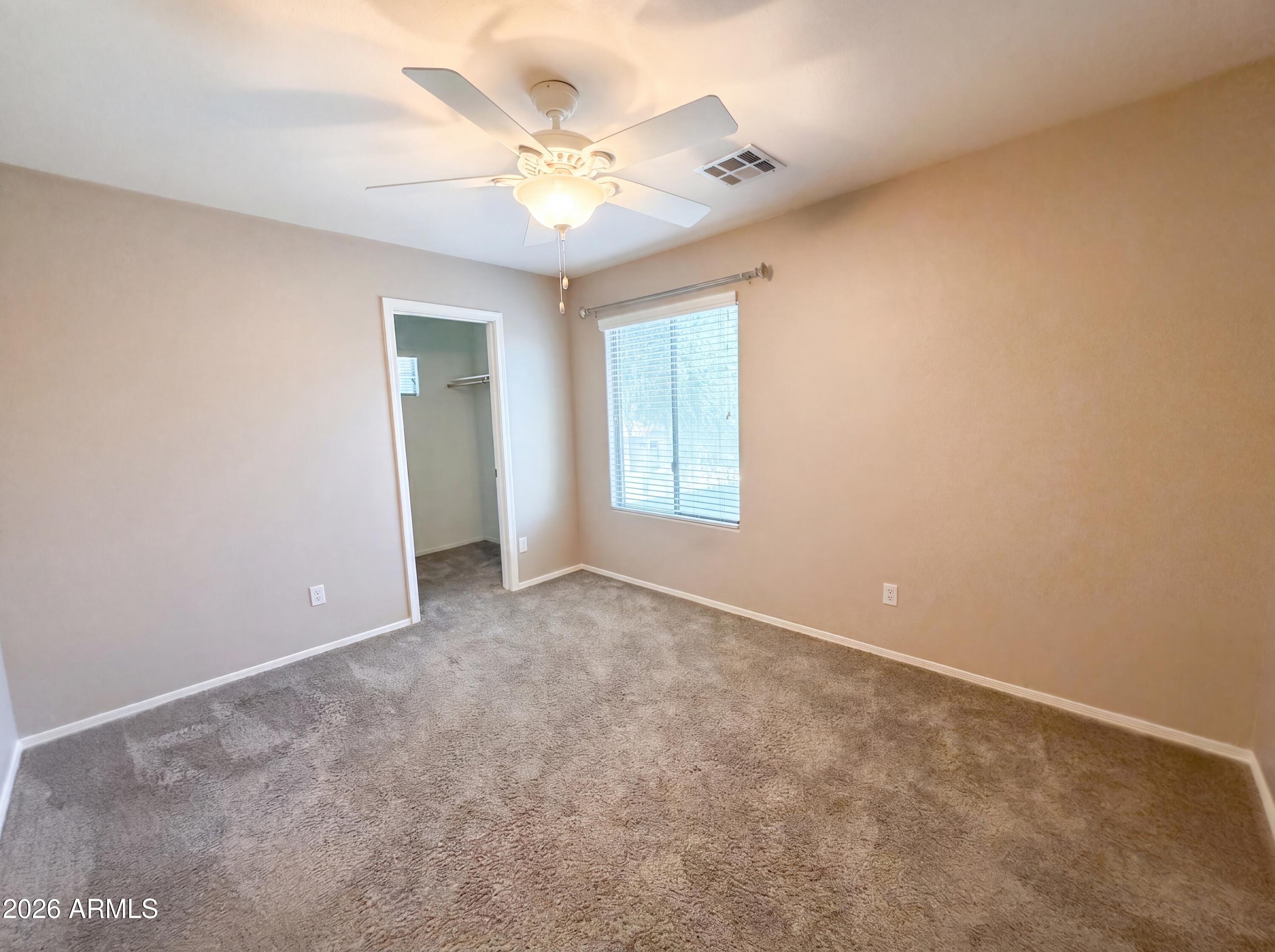 1565 East Hopkins Road Gilbert, AZ 85295 - Photo 11 of 29 an empty room with a chandelier fan and windows