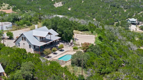 an aerial view of a house with swimming pool and garden