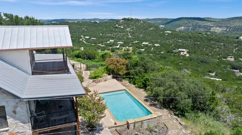 an aerial view of a house with a yard and mountain view in back