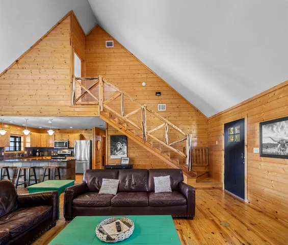 a view of a house with couches chairs and wooden floor