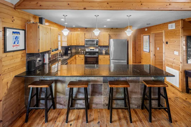 a kitchen with stainless steel appliances granite countertop a table chairs and a refrigerator