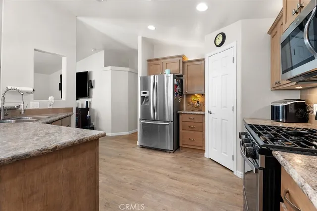 a kitchen with stainless steel appliances granite countertop a refrigerator stove and oven