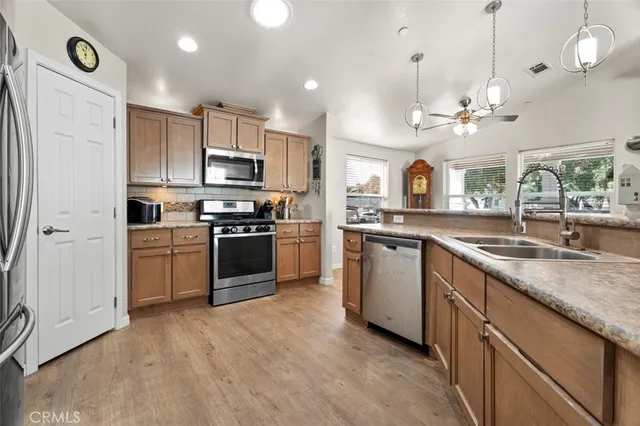 a kitchen with cabinets stainless steel appliances and a chandelier