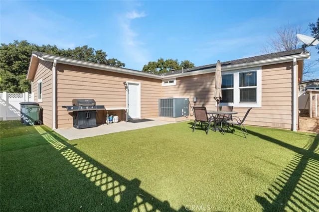 a view of a house with patio and a yard