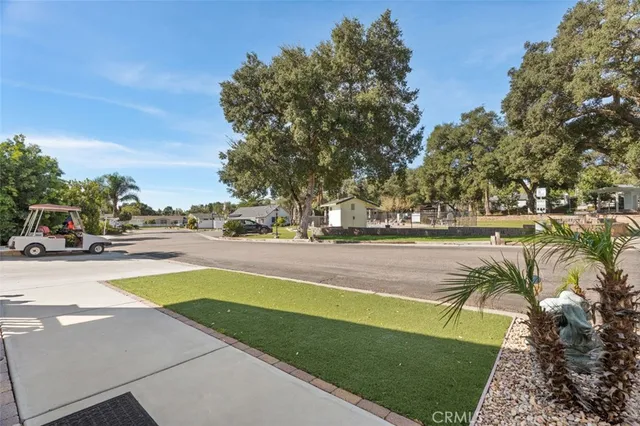 a view of swimming pool with outdoor seating and trees in the background