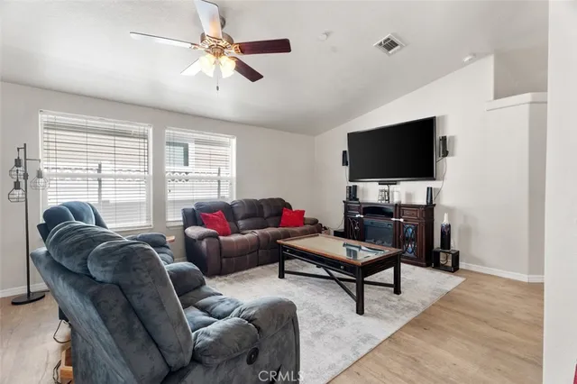 a living room with furniture a flat screen tv and a large window