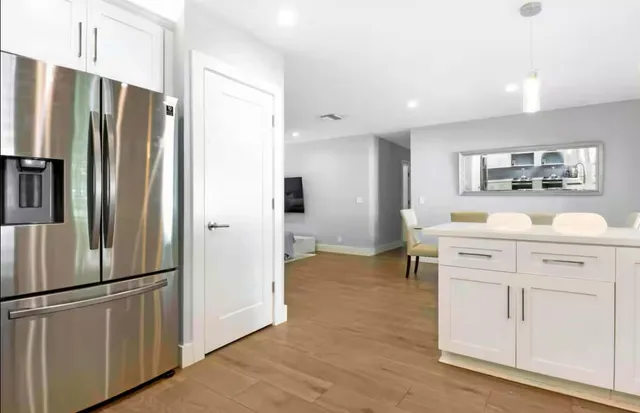 a kitchen with white cabinets and stainless steel appliances