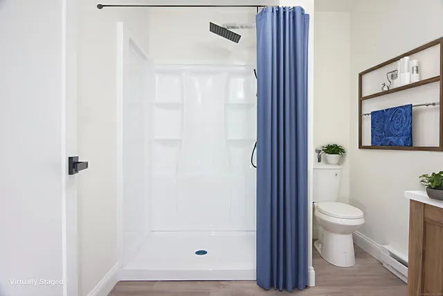 a bathroom with a toilet and a shower