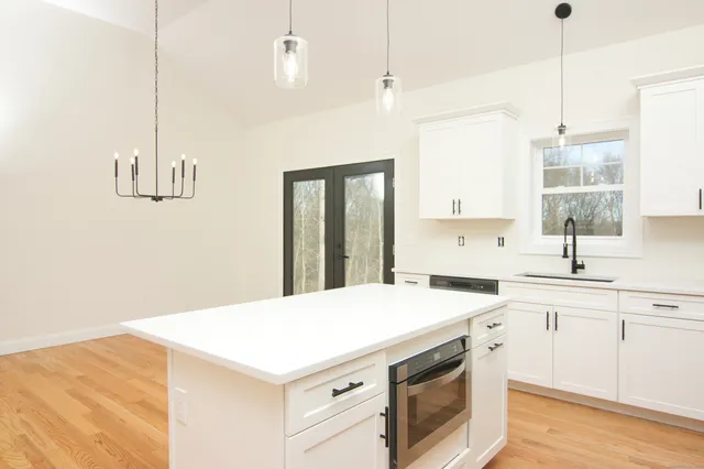 a kitchen with a stove a sink a center island and a window