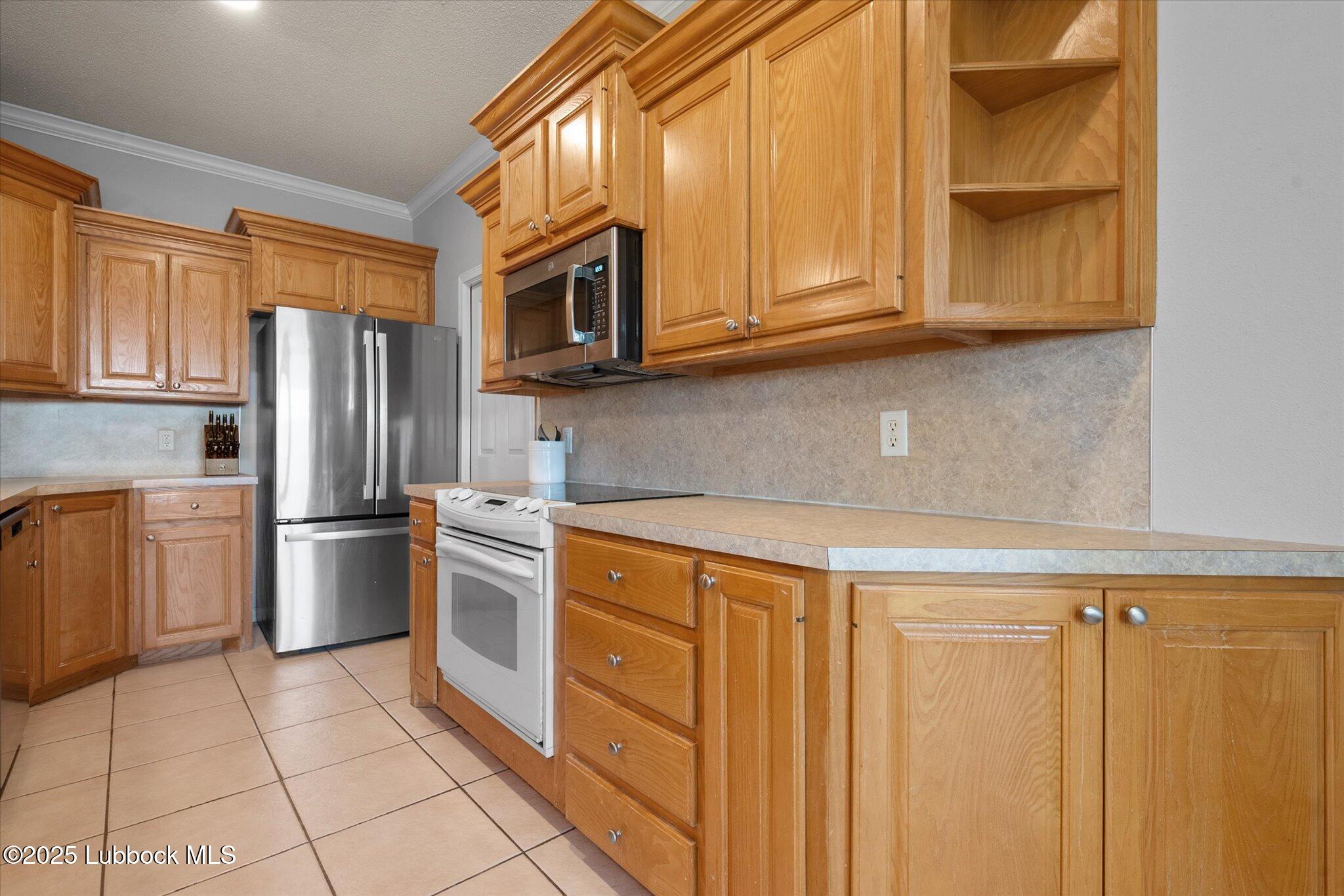 10401 Elgin Avenue Lubbock, TX 79423 - Photo 11 of 27 a kitchen with stainless steel appliances granite countertop a refrigerator and cabinets