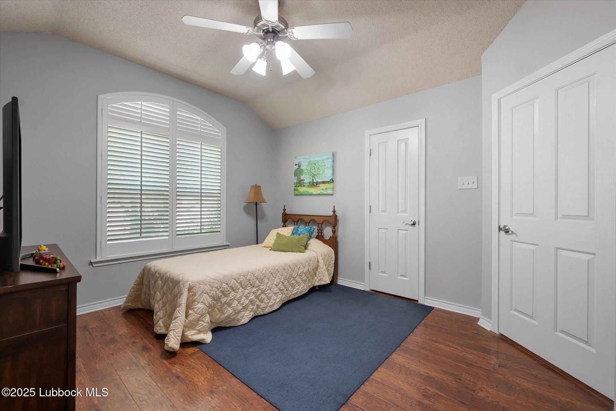 10401 Elgin Avenue Lubbock, TX 79423 - Photo 13 of 27 a bedroom with a bed and wooden floor