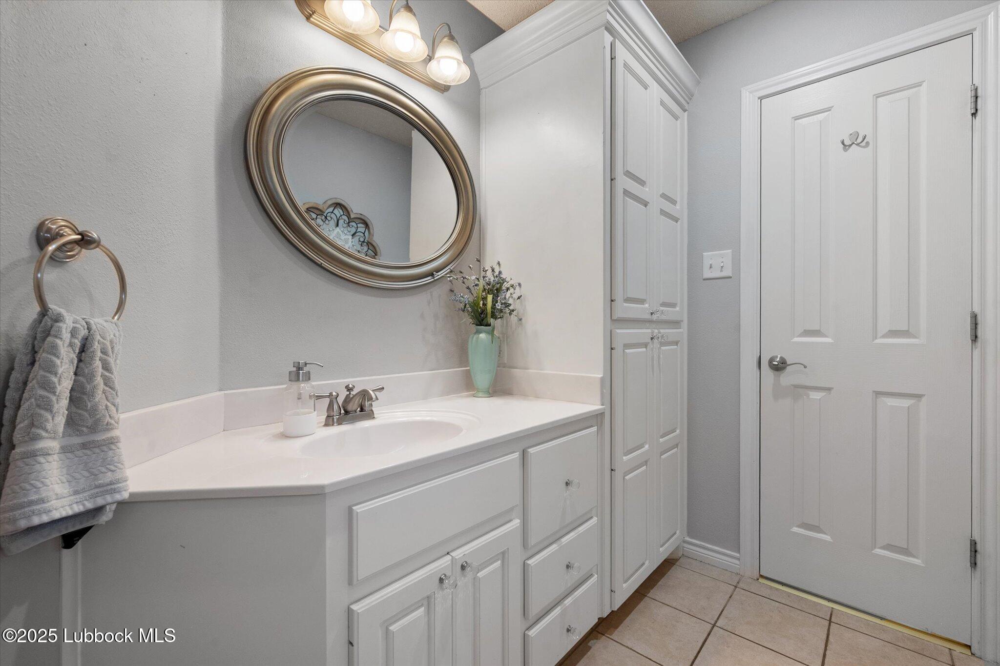 10401 Elgin Avenue Lubbock, TX 79423 - Photo 14 of 27 a bathroom with a sink a mirror and a shower