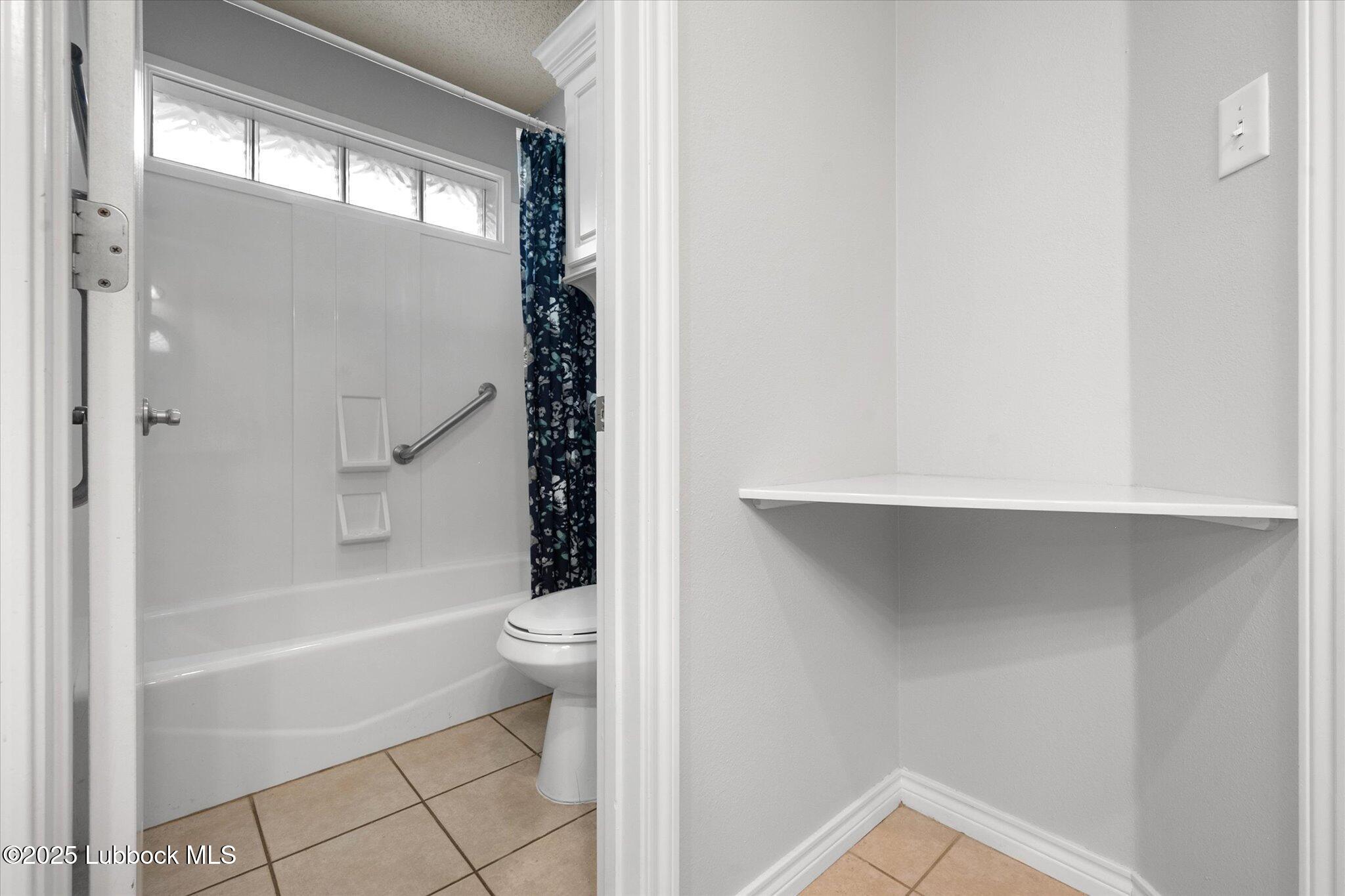 10401 Elgin Avenue Lubbock, TX 79423 - Photo 15 of 27 a bathroom with a toilet and a bathtub