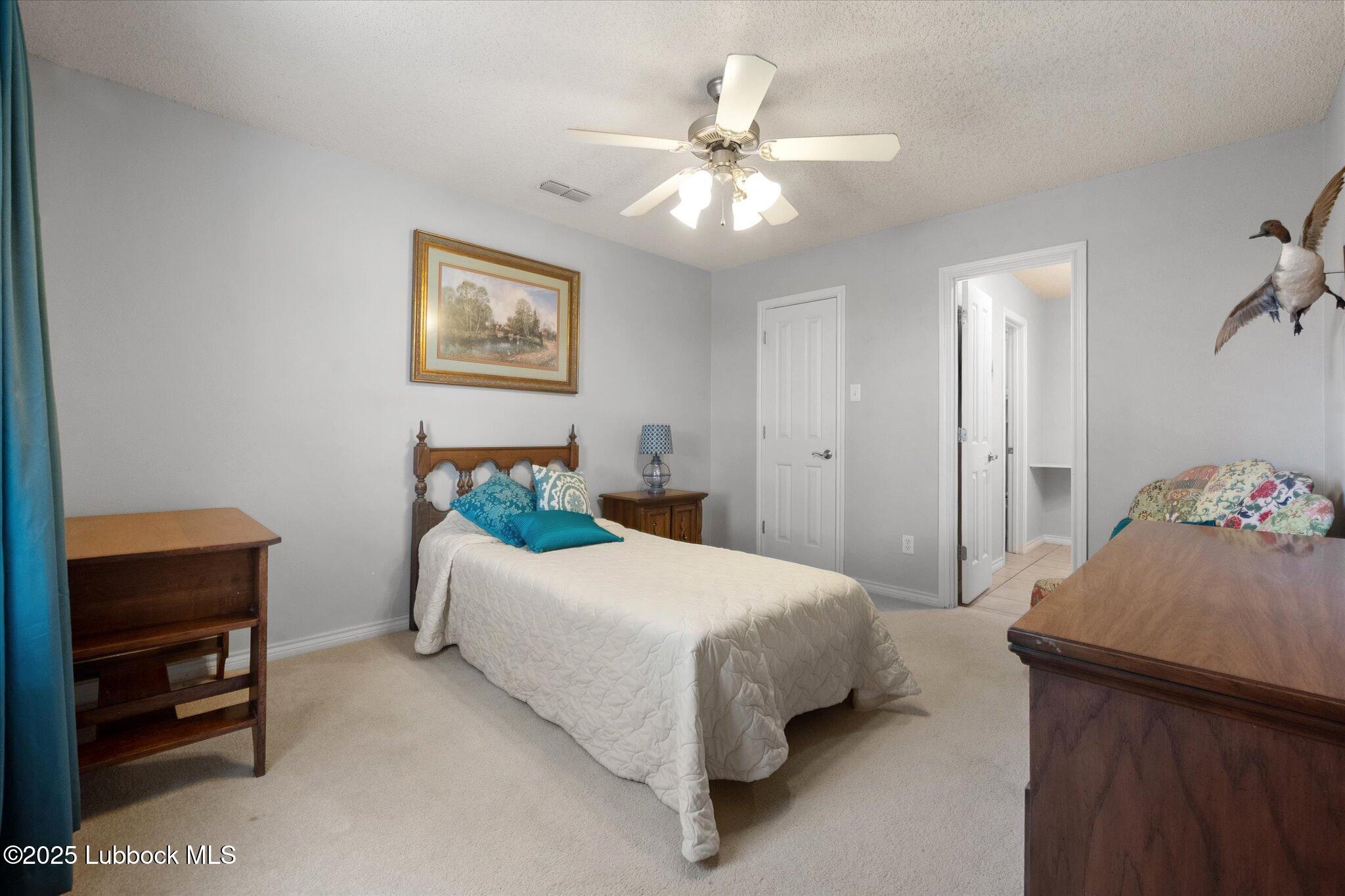 10401 Elgin Avenue Lubbock, TX 79423 - Photo 16 of 27 a bedroom with a bed and a chandelier
