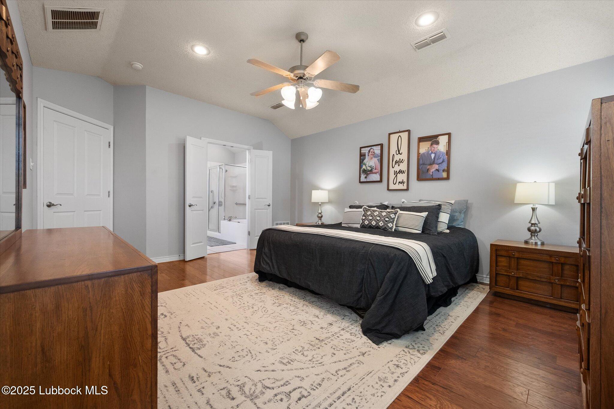 10401 Elgin Avenue Lubbock, TX 79423 - Photo 18 of 27 a bedroom with a large bed and a chandelier