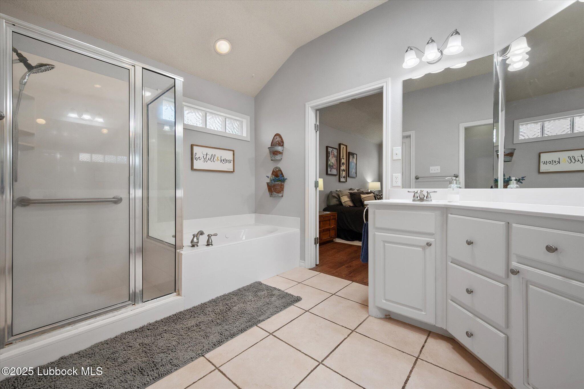10401 Elgin Avenue Lubbock, TX 79423 - Photo 20 of 27 a spacious bathroom with a shower a mirror and a sink