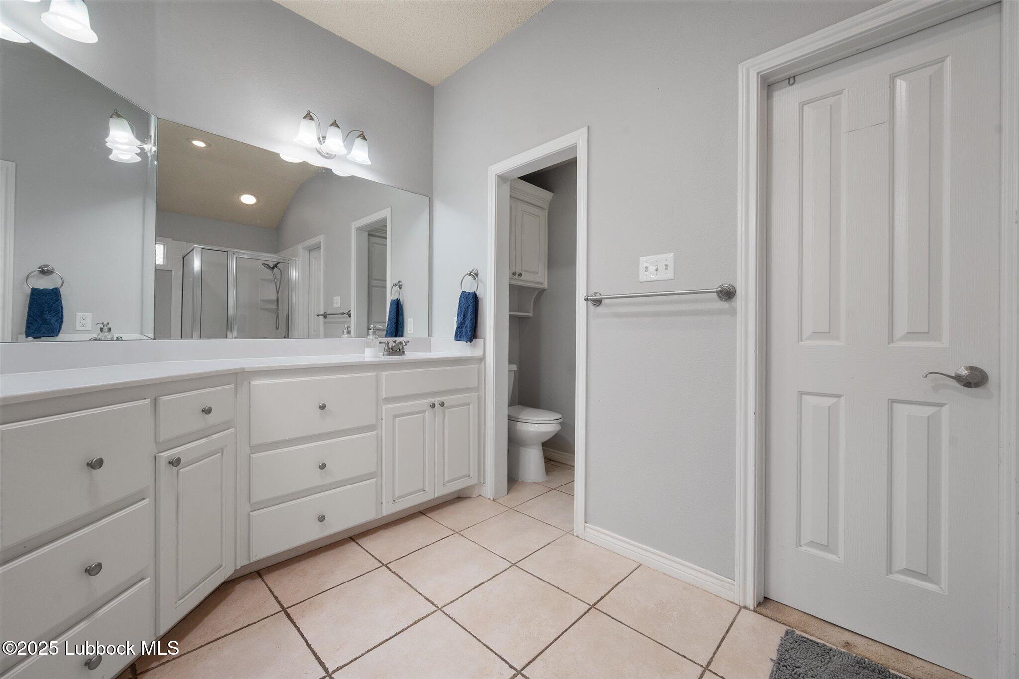 10401 Elgin Avenue Lubbock, TX 79423 - Photo 22 of 27 a spacious bathroom with a double vanity sink a mirror and a