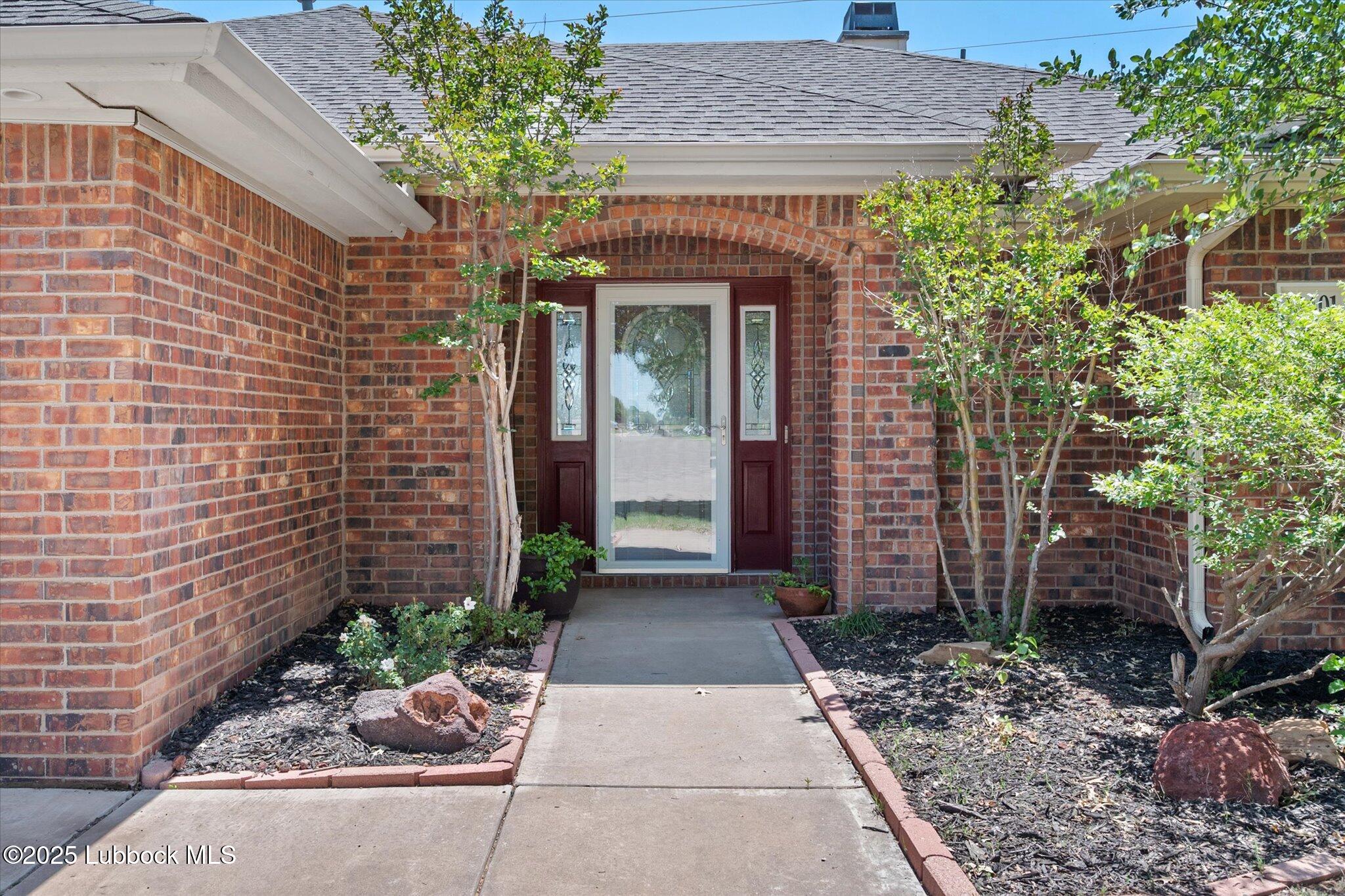10401 Elgin Avenue Lubbock, TX 79423 - Photo 4 of 27 a stone house with potted plants in front of door