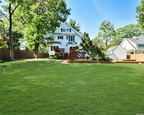 a front view of a house with a yard and trees