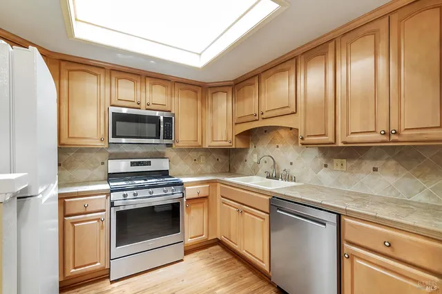 a kitchen with stainless steel appliances granite countertop a sink a stove and microwave