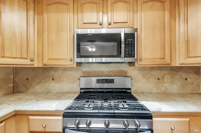 a stove top oven sitting inside of a kitchen