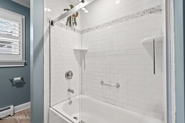 a bathroom with a white bath tub with a shower