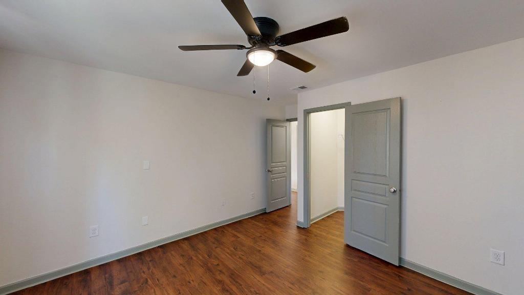 2499 Sinclair Trace Powder Springs, GA 30127 - Photo 29 of 42 an empty room with wooden floor ceiling fan and windows