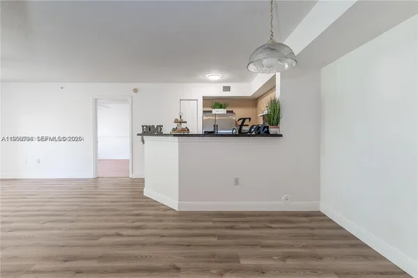 a view of a kitchen and an empty room