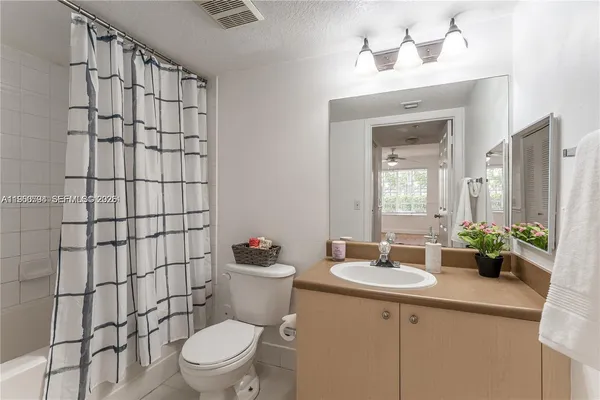 a bathroom with a sink a toilet and shower curtain