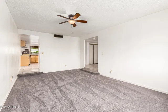 a view of a livingroom with a ceiling fan and window