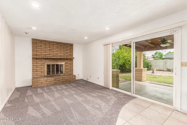 a view of an empty room with a fireplace and a large window